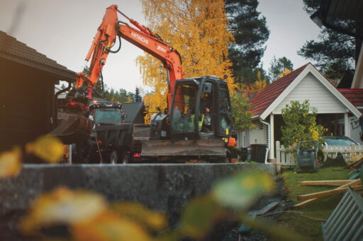 Gravemaskin i arbeid på en eiendom